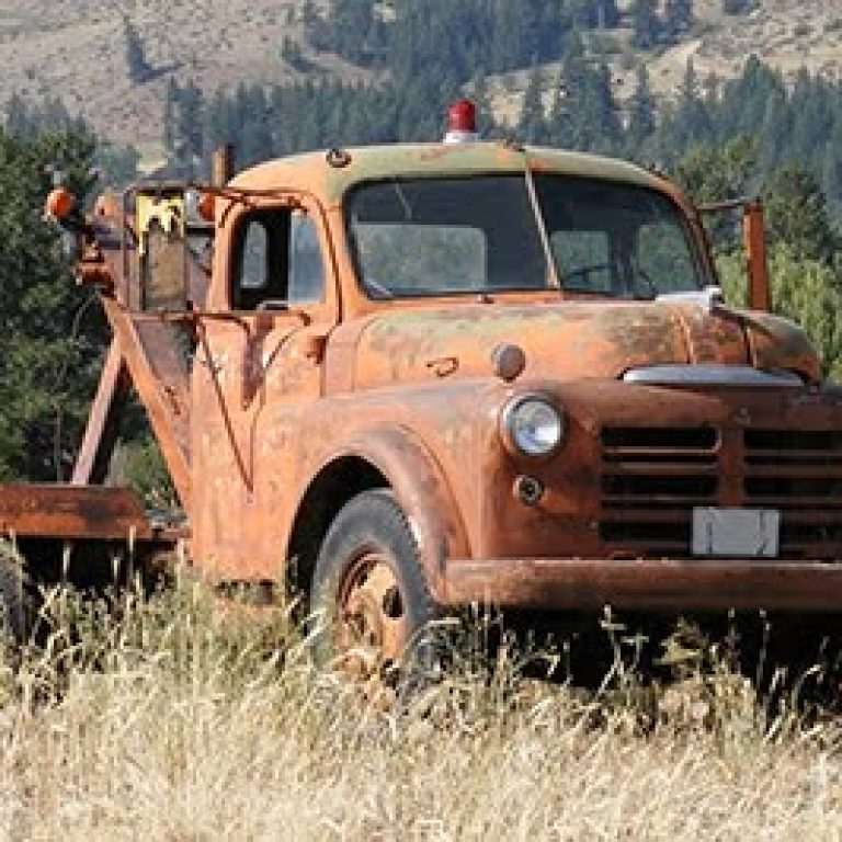 Abandoned 1940's Tow Truck parked in a field
